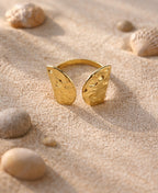 Golden Tide 18K Adjustable Ring with hammered gold texture placed on sand with seashells