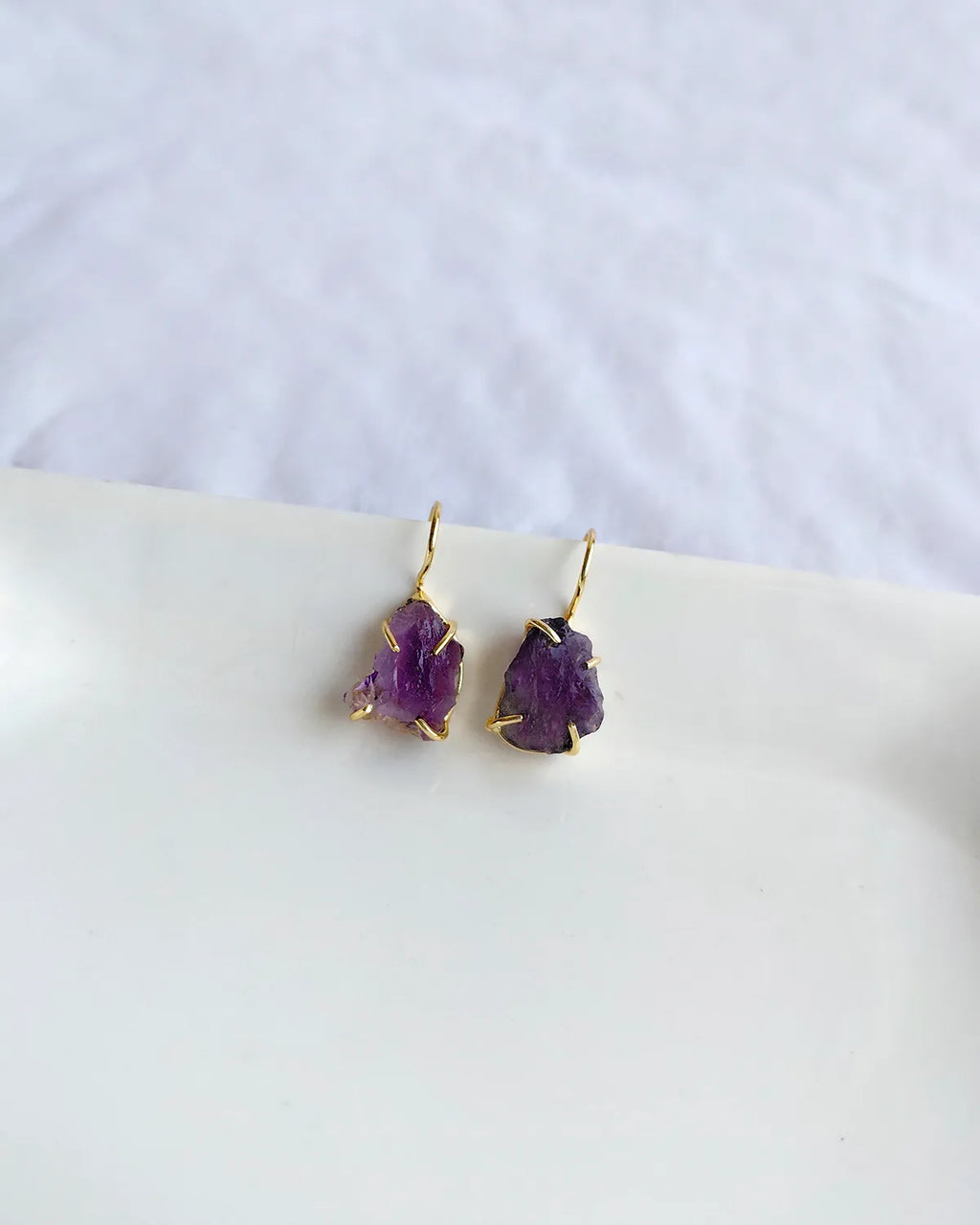 Raw purple amethyst earrings with gold-tone hook settings