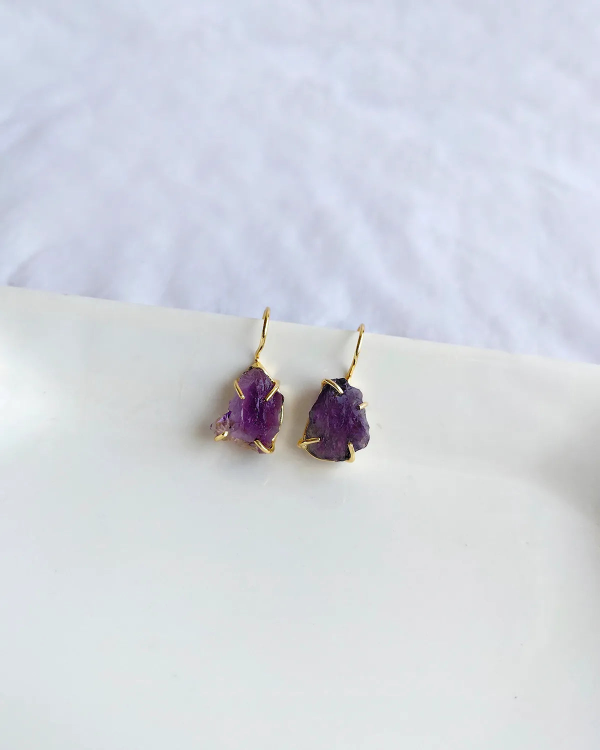 Raw purple amethyst earrings with gold-tone hook settings
