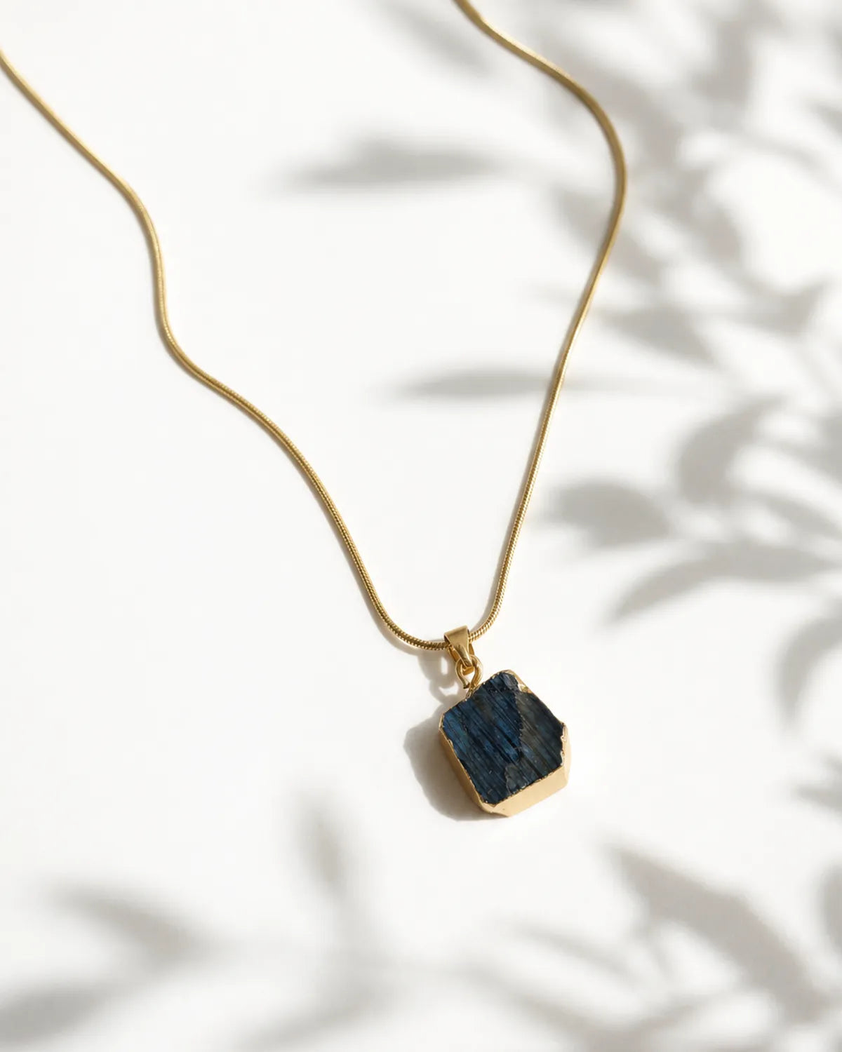 Raw labradorite gold pendant necklace on white background