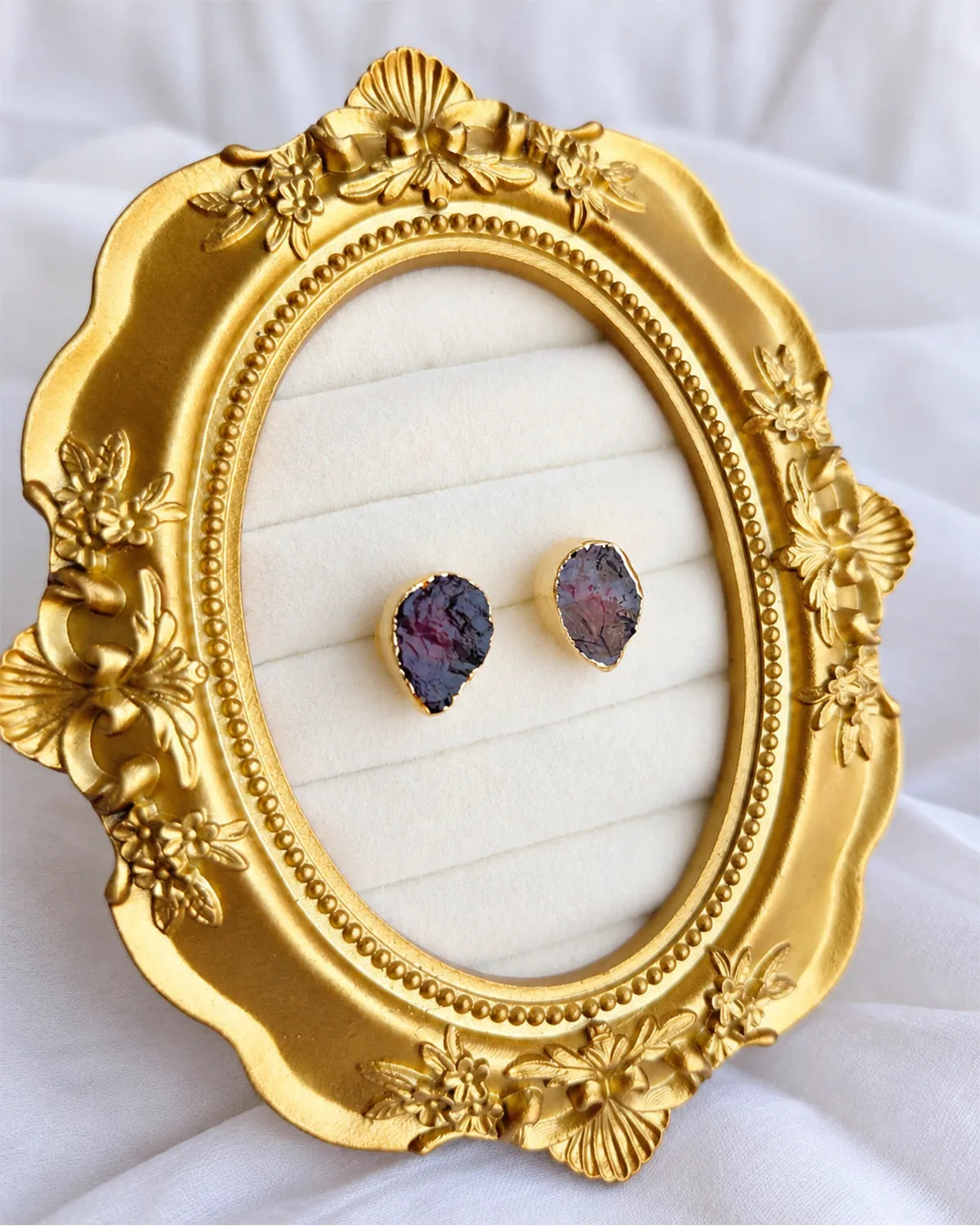 Purple gemstone gold stud earrings on ornate frame