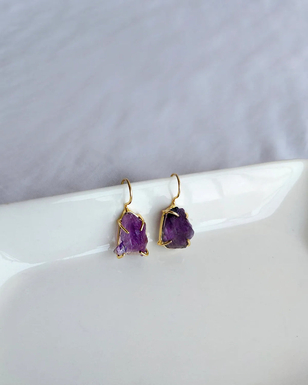 Raw purple amethyst earrings with gold-tone hook settings