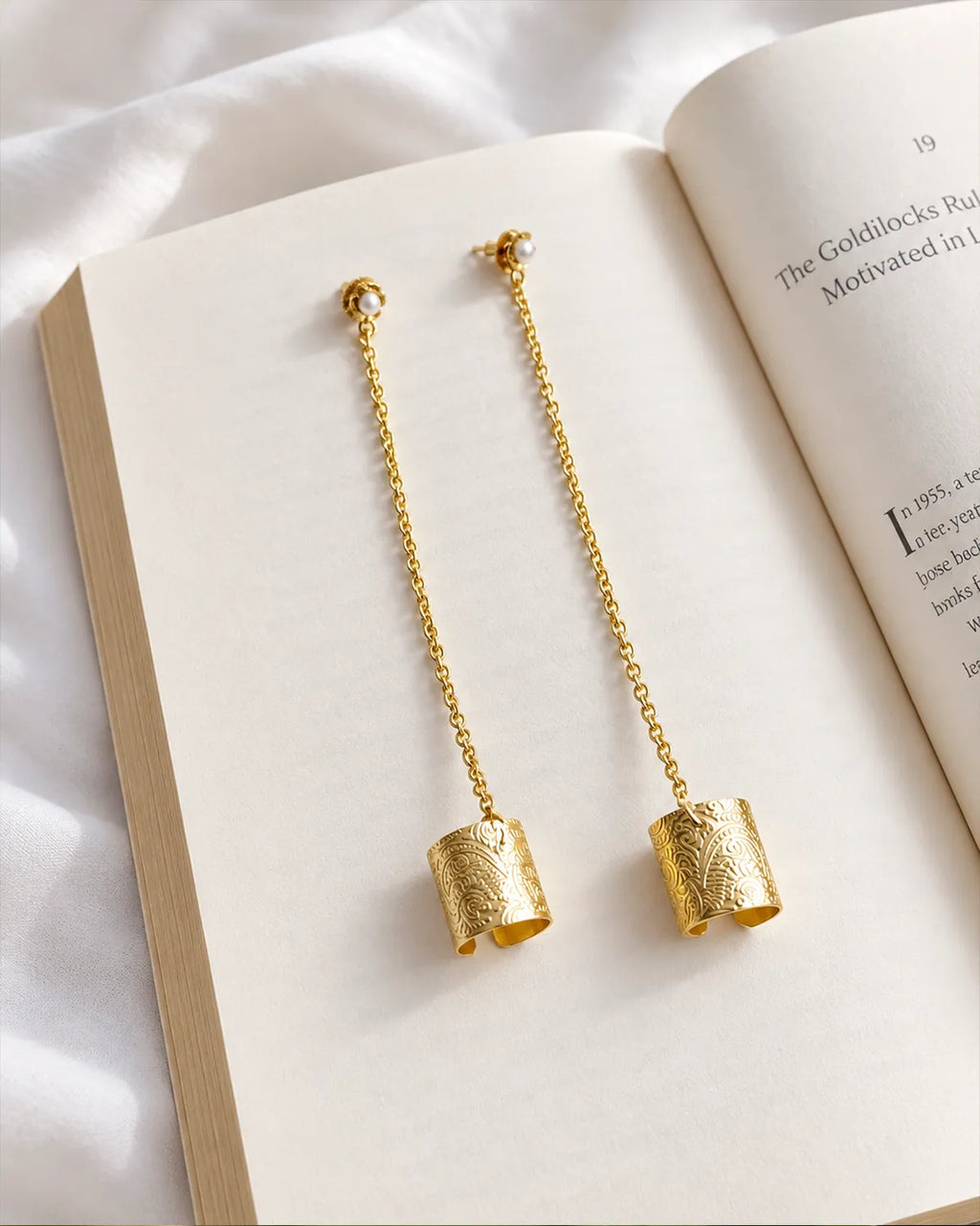 Engraved gold plated ear cuff chain earrings flat lay