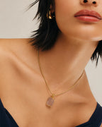 Raw rose quartz gold pendant necklace worn on model