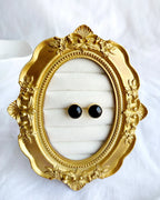Classic round black stud earrings in gold-tone setting