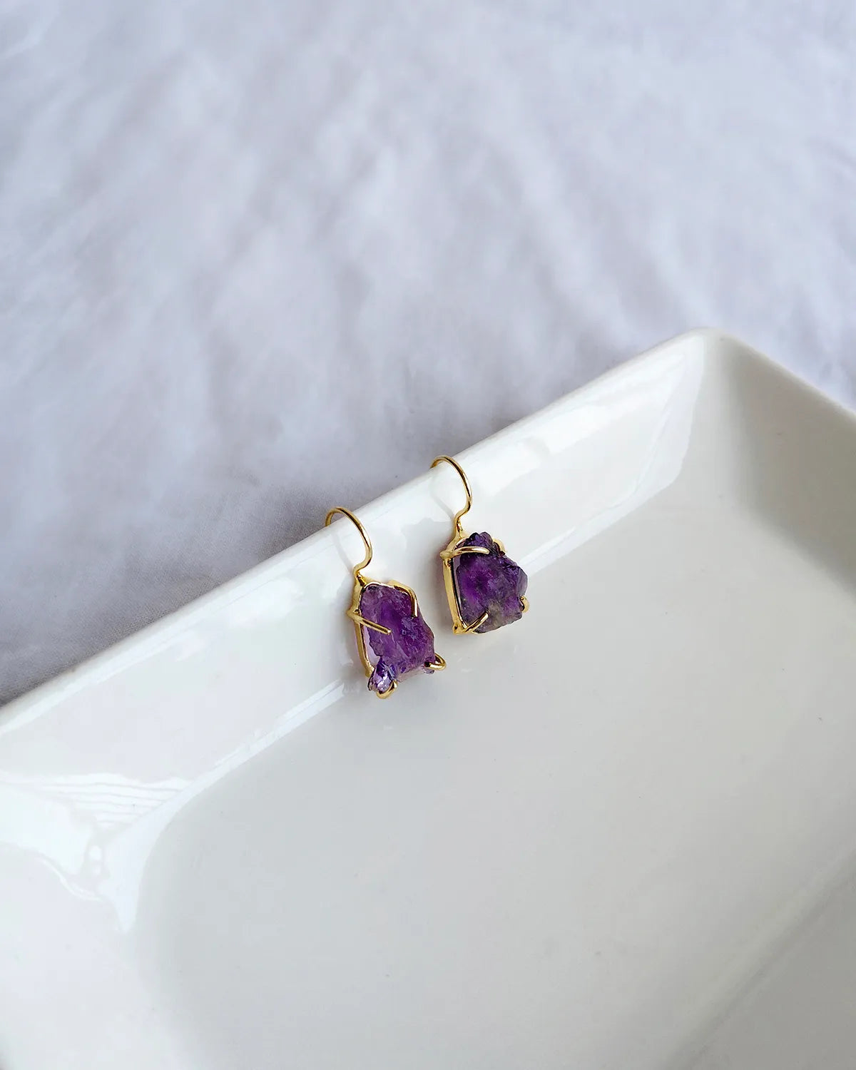 Raw purple amethyst earrings with gold-tone hook settings