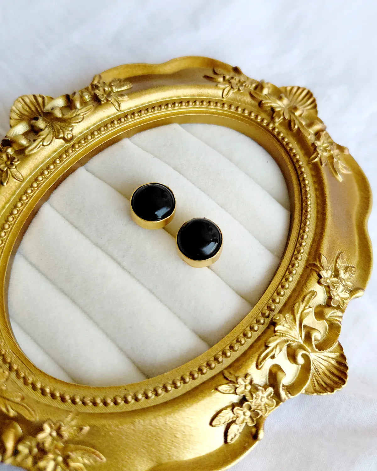 Classic round black stud earrings in gold-tone setting