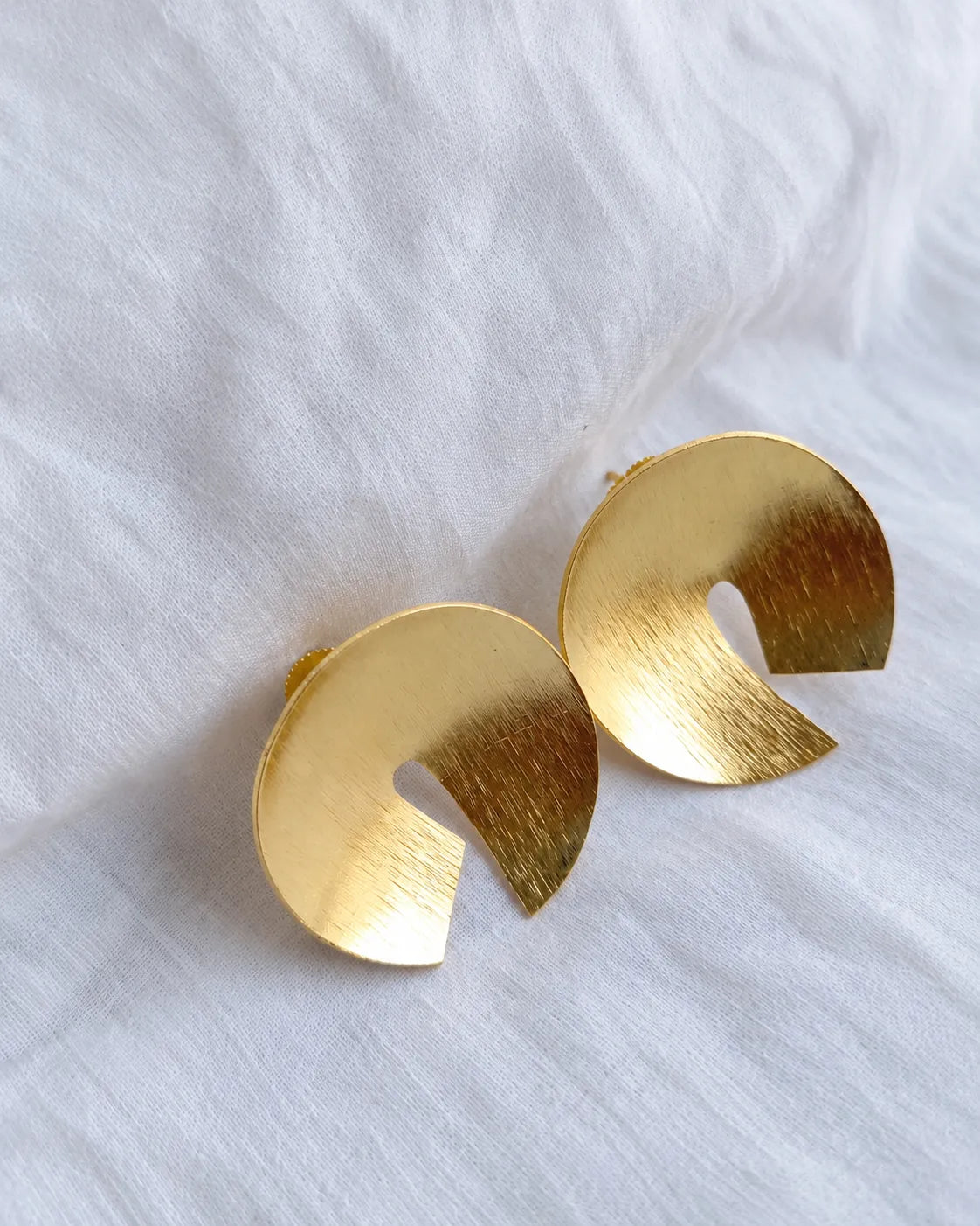 Close-up of textured gold disc earrings