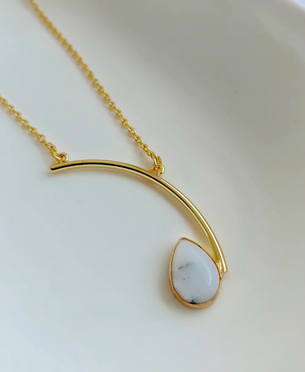 Ivory Arc Howlite 18K Gold Plated Necklace with white teardrop gemstone and curved gold pendant design.