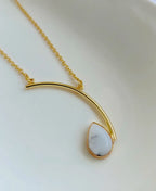 Ivory Arc Howlite 18K Gold Plated Necklace with white teardrop gemstone and curved gold pendant design.