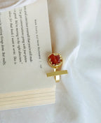 Gold bookmark with a red gemstone on an open book