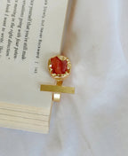Gold pendant with a red stone on a book page