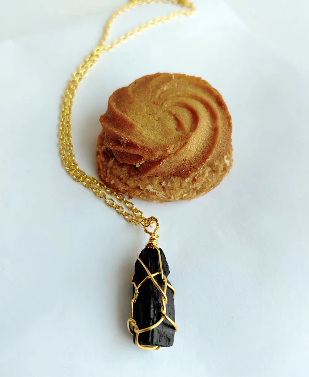 Noir Shield Black Tourmaline Pendant with natural raw black tourmaline crystal and 18K gold-plated wire-wrapped design.
