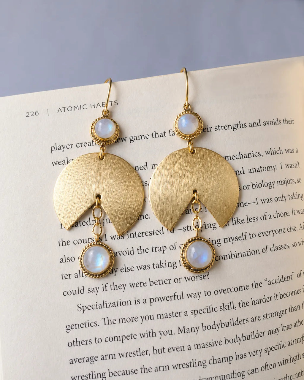 Moonstone gold earrings styled on book