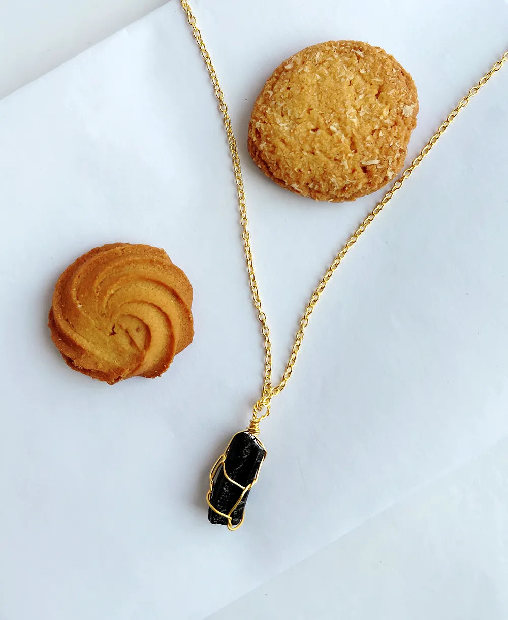 Noir Shield Black Tourmaline Pendant with natural raw black tourmaline crystal and 18K gold-plated wire-wrapped design.