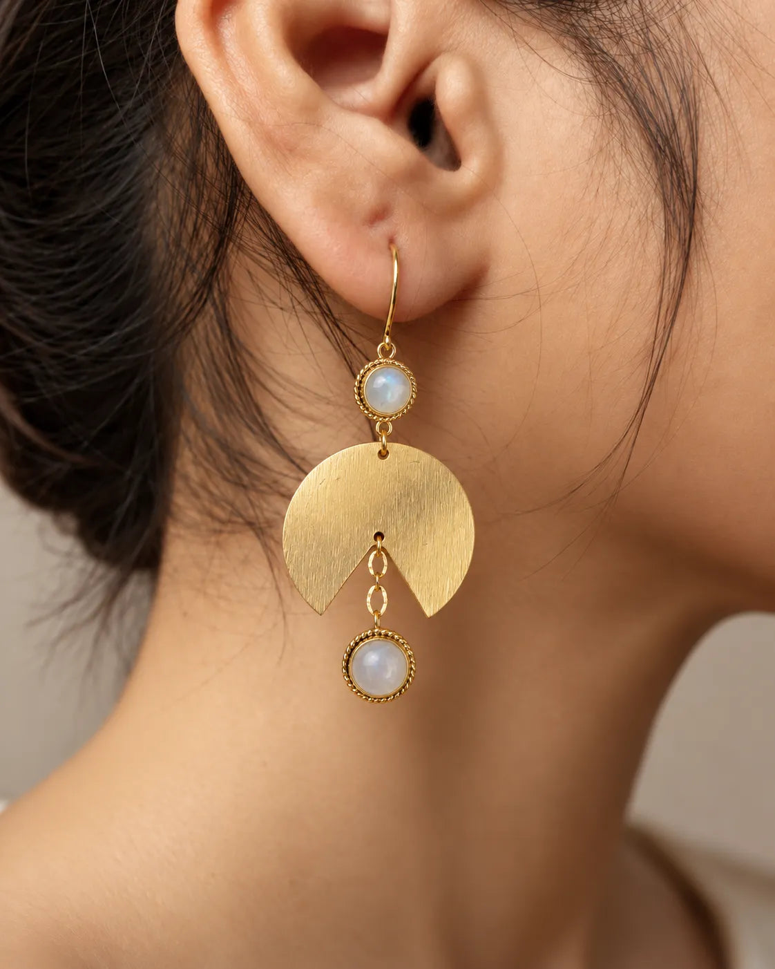 Moonstone gold fan earring worn on model