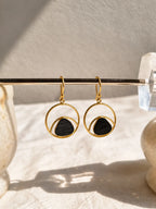Black stone gold orbit earrings on display rod
