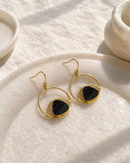 Black stone gold orbit earrings on stone tray