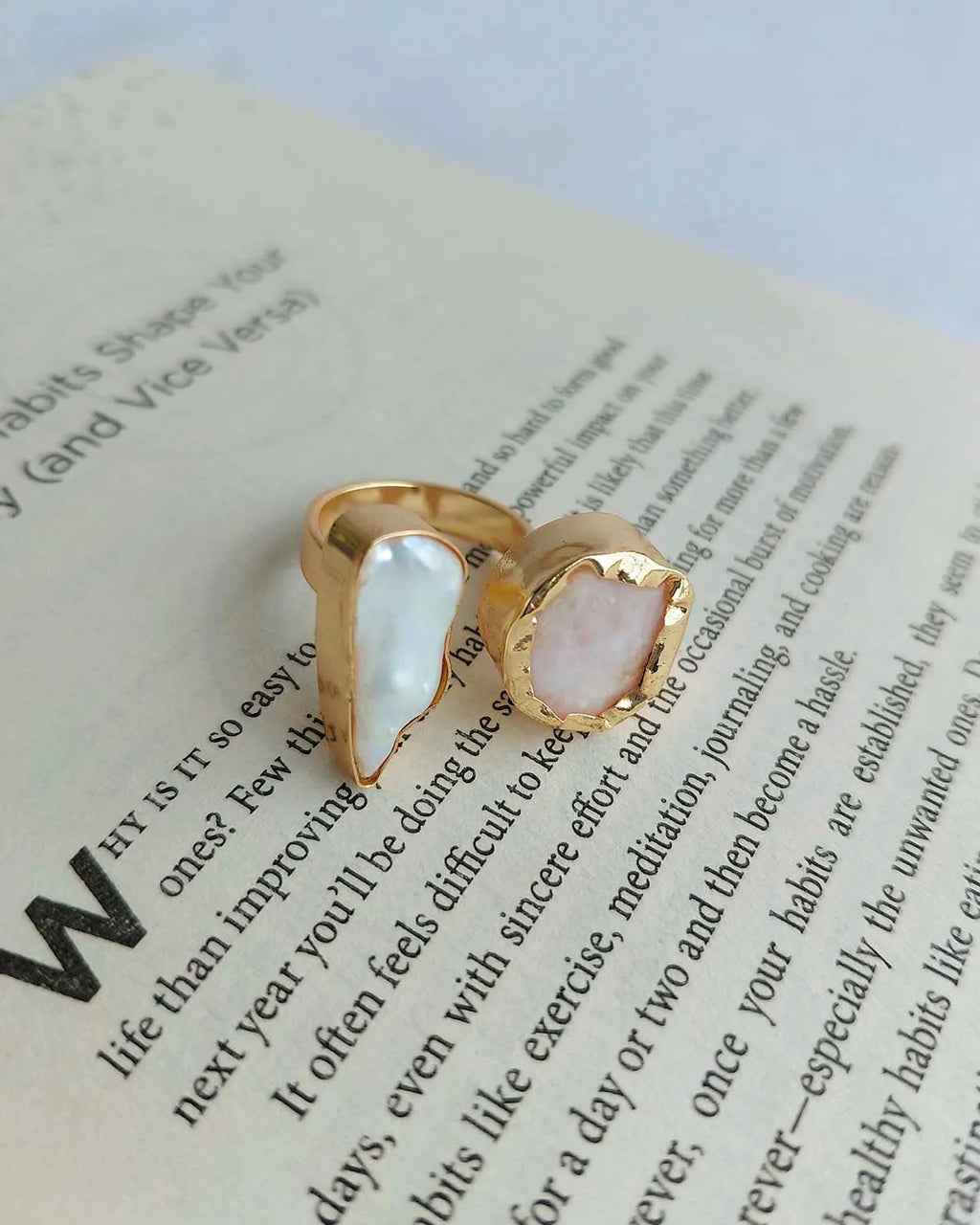 Gold plated dual stone ring photographed on an open book