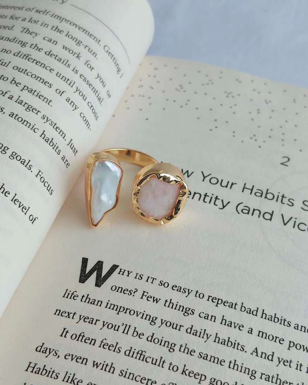 Gold plated dual stone ring with white and blush natural stones on book pages