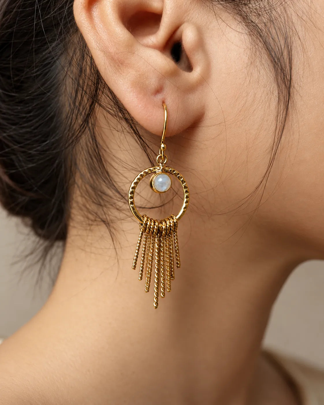 Moonstone gold tassel earrings worn on ear