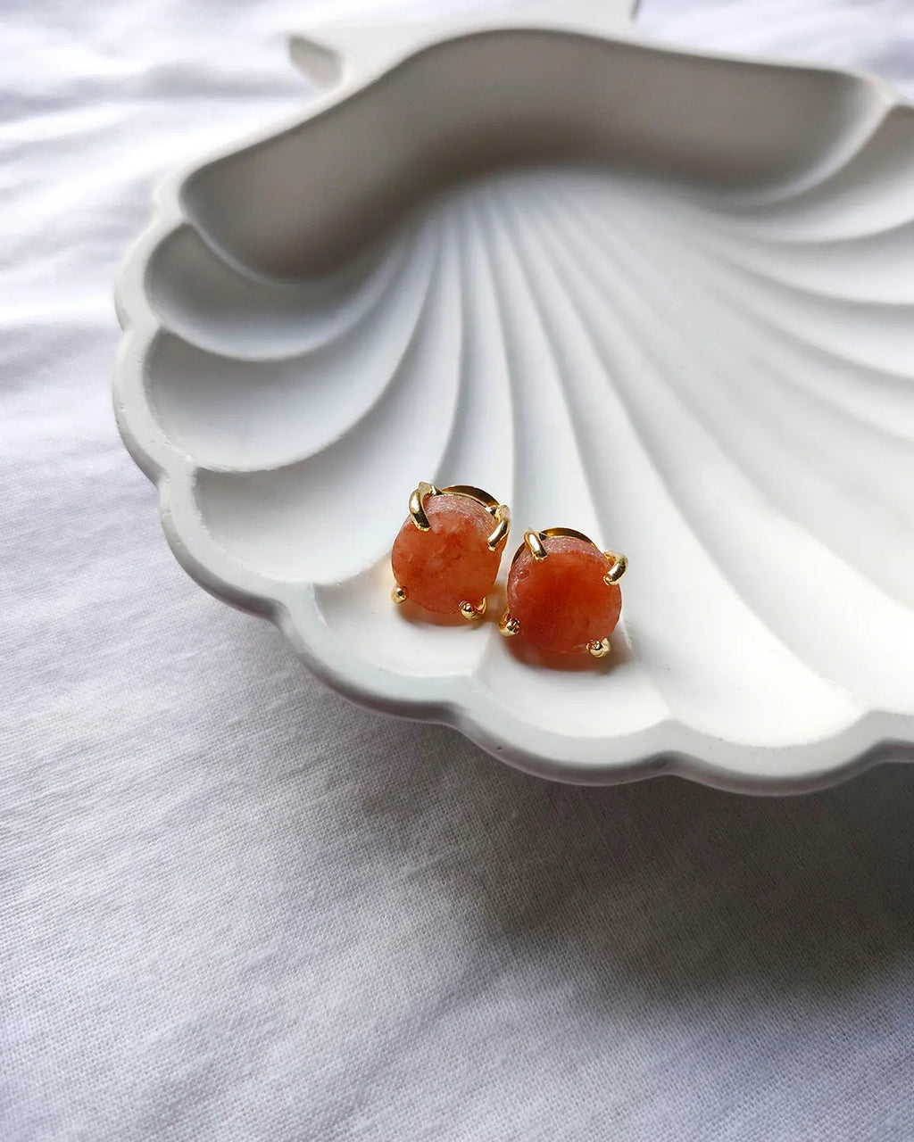 Peach raw stone gold stud earrings front view