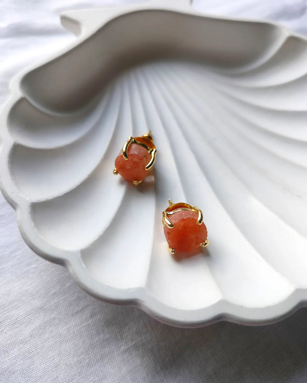 Peach raw stone gold stud earrings angled view