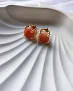Peach raw stone gold stud earrings close-up