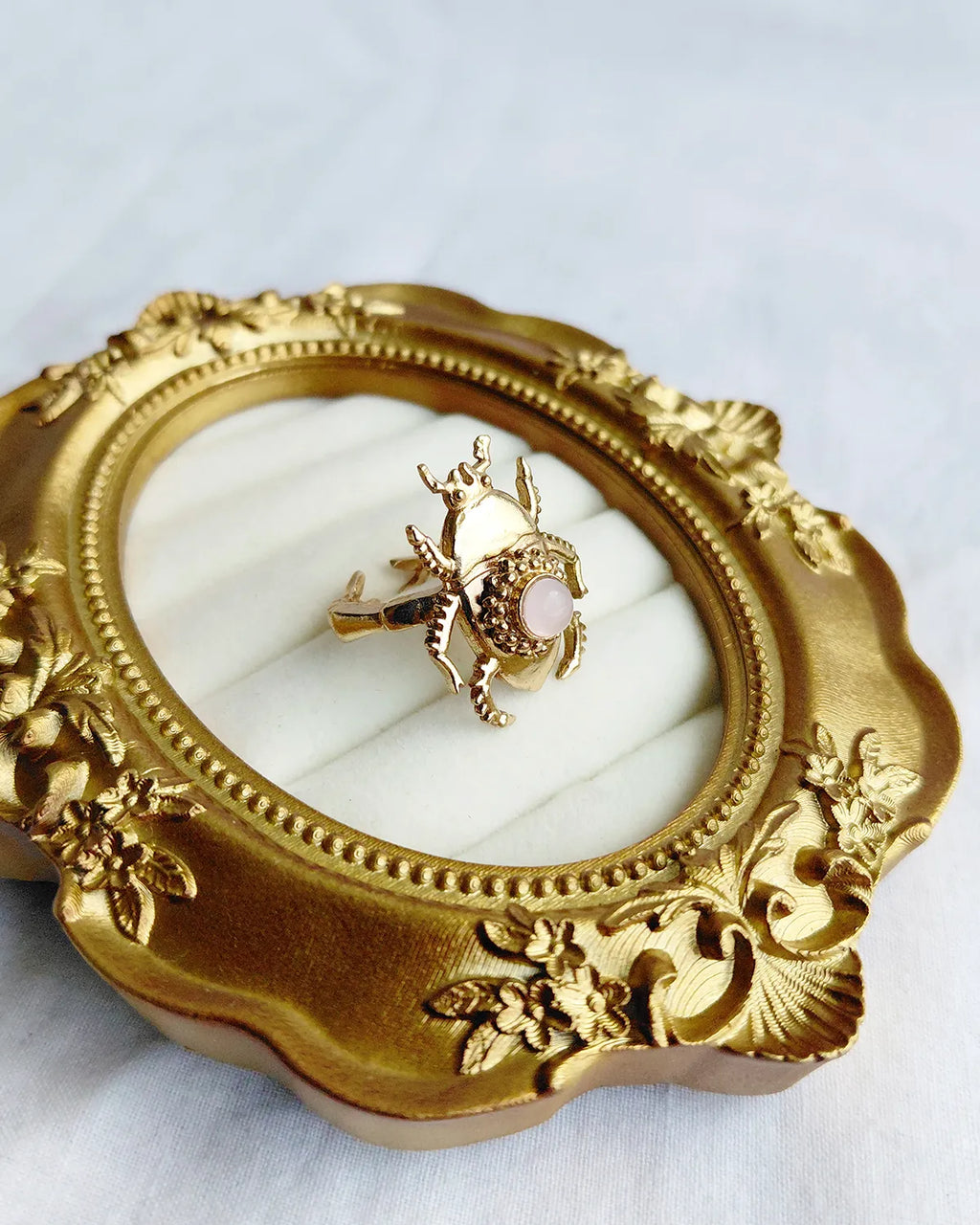 Pink stone scarab gold plated ring close angled view