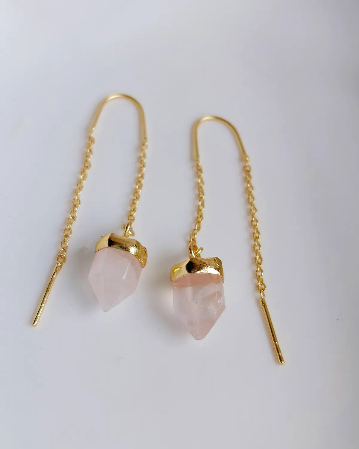 Close-up of natural Rose Quartz threader earrings with gold-plated chain