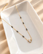 Gold-tone black bead mangalsutra with rectangular and round clear stone duo pendant