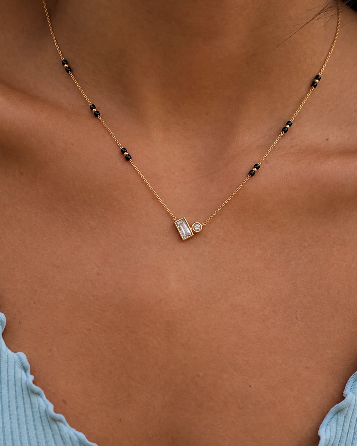 Gold-tone black bead mangalsutra with rectangular and round clear stone duo pendant