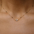 Floral sprig pendant mangalsutra with delicate black beads and gold-tone chain