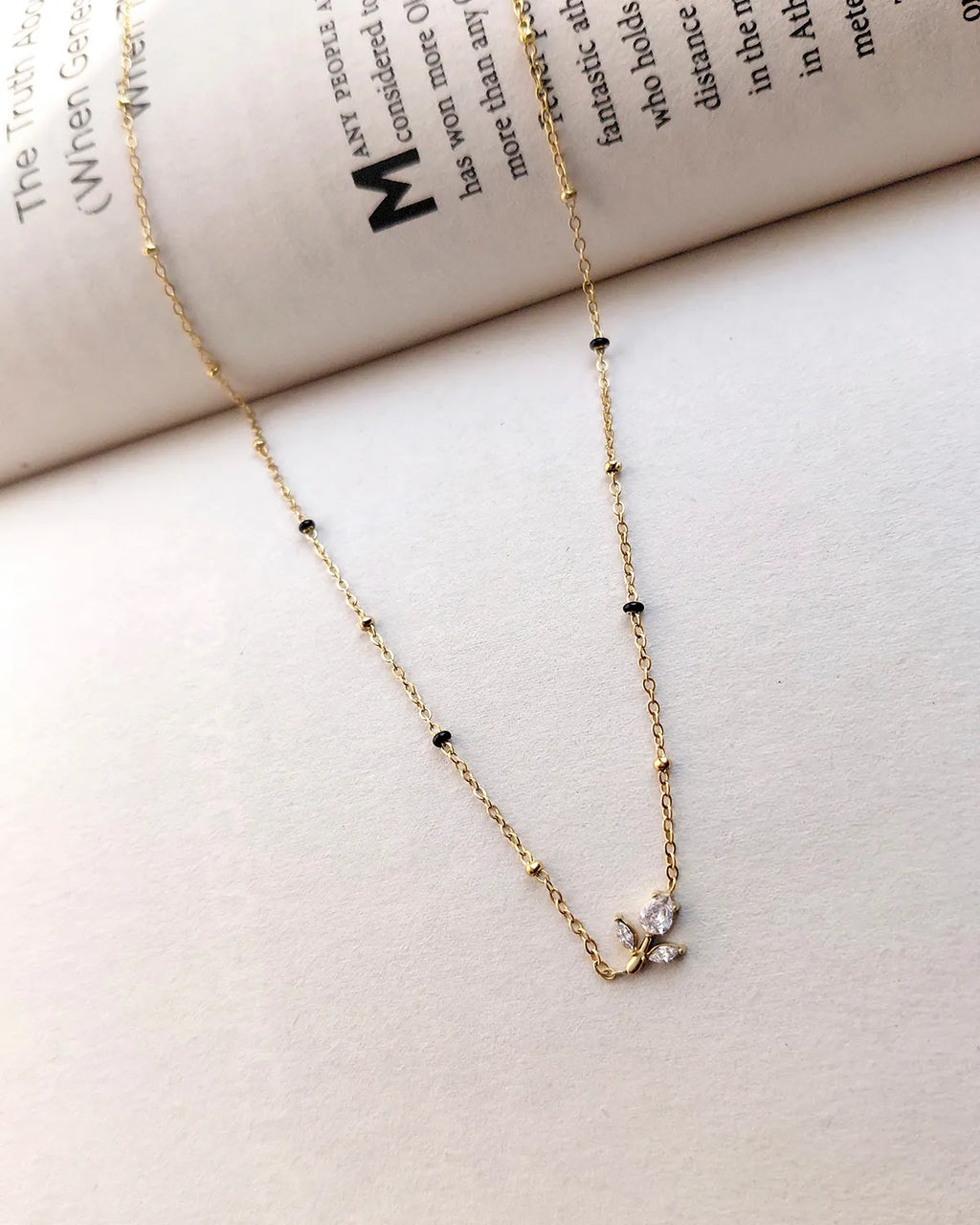 Floral sprig pendant mangalsutra with delicate black beads and gold-tone chain