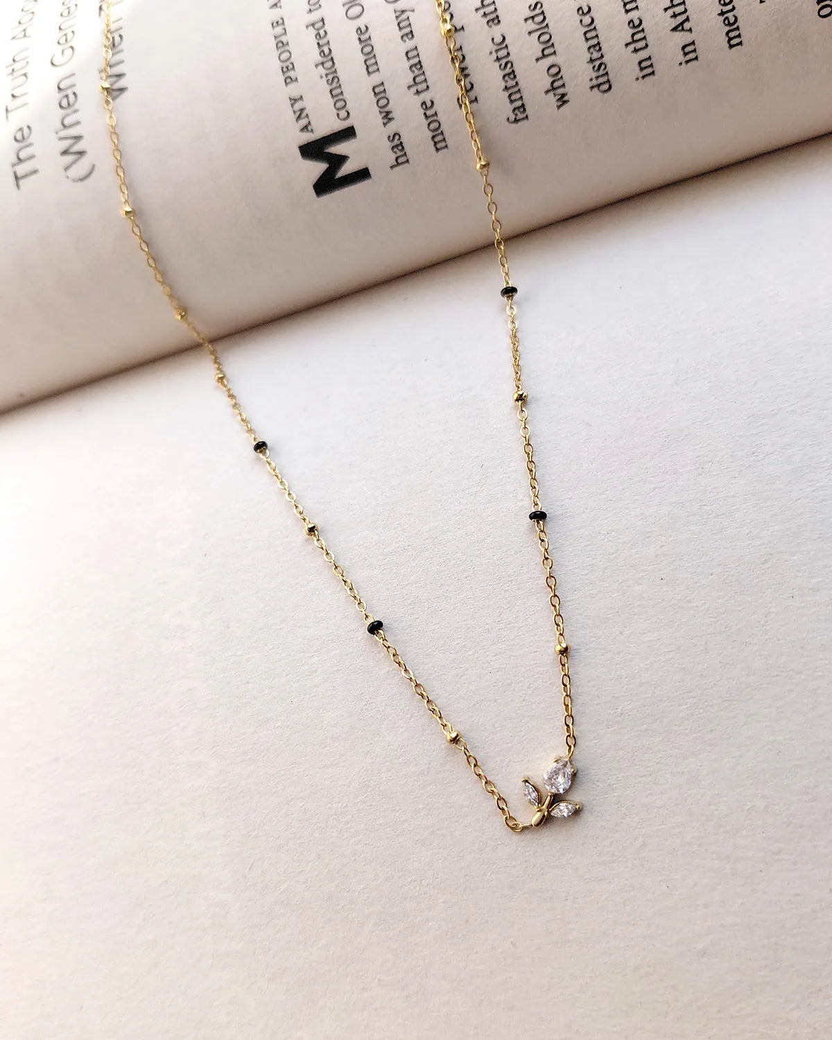 Floral sprig pendant mangalsutra with delicate black beads and gold-tone chain
