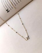 Floral sprig pendant mangalsutra with delicate black beads and gold-tone chain