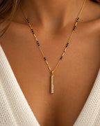 Long vertical gold bar pendant with sparkling clear stones and black bead mangalsutra chain