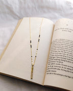 Long vertical gold bar pendant with sparkling clear stones and black bead mangalsutra chain