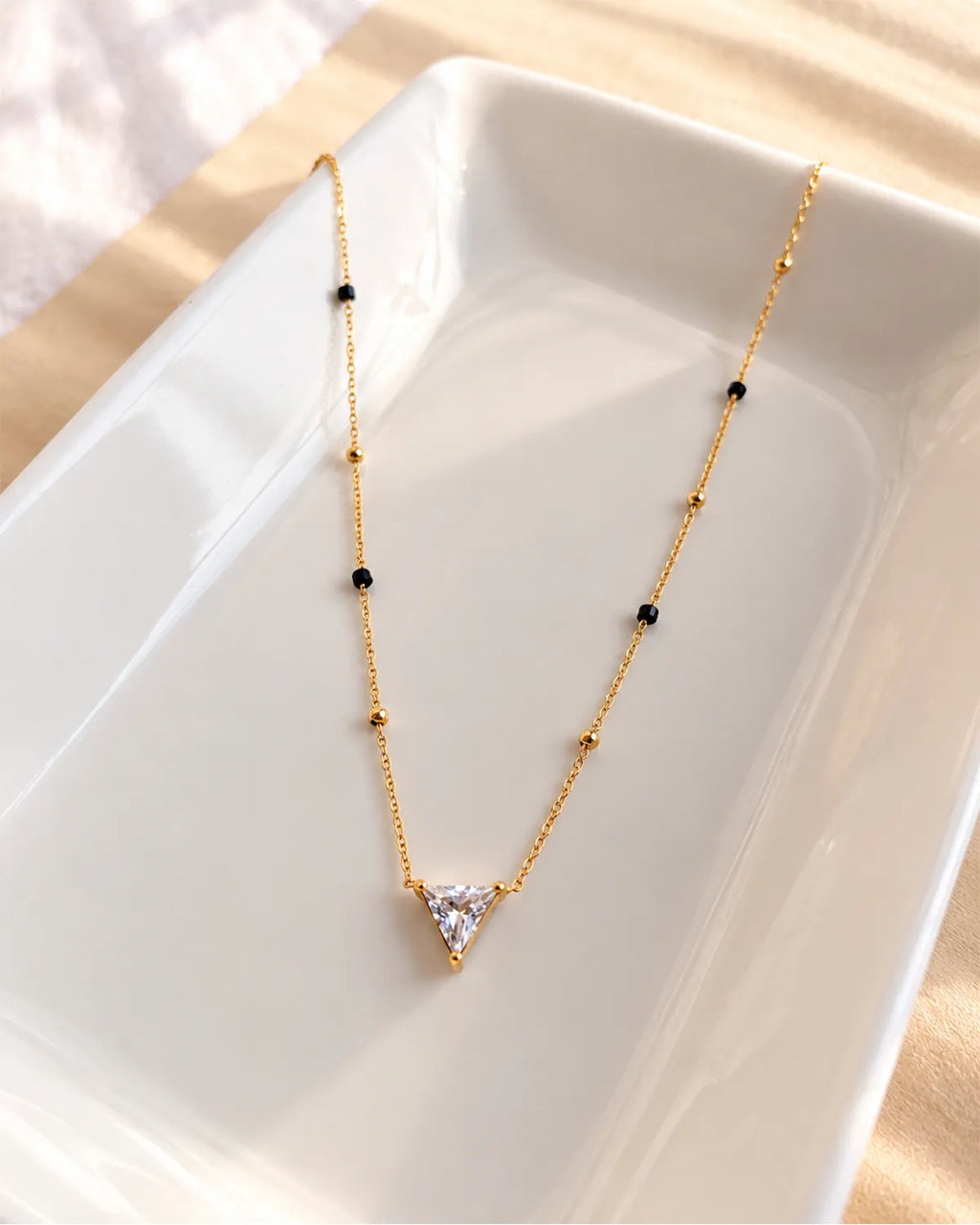 Triangle solitaire-style clear stone pendant mangalsutra with black and gold beads