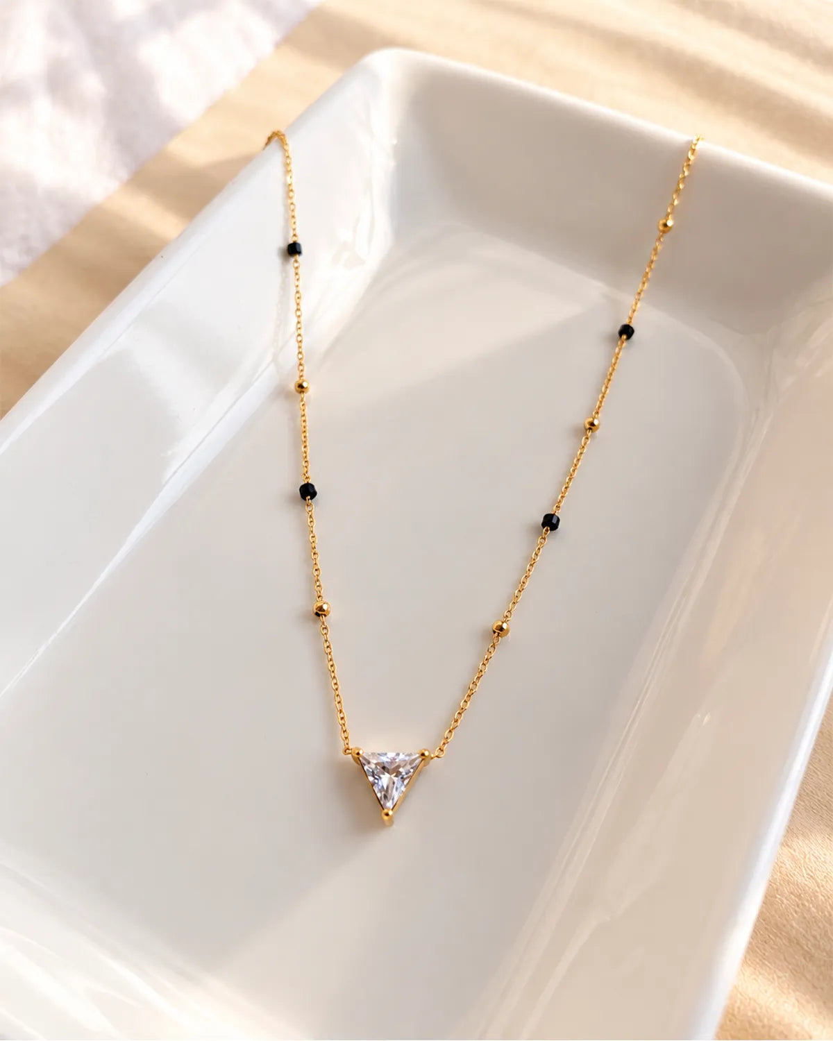 Triangle solitaire-style clear stone pendant mangalsutra with black and gold beads