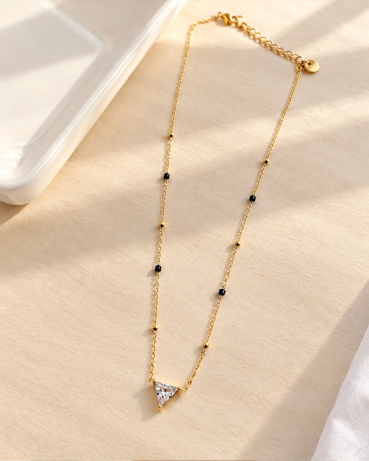 Triangle solitaire-style clear stone pendant mangalsutra with black and gold beads