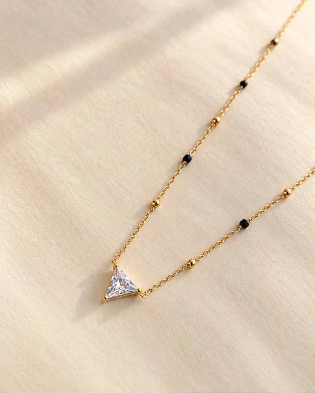 Triangle solitaire-style clear stone pendant mangalsutra with black and gold beads